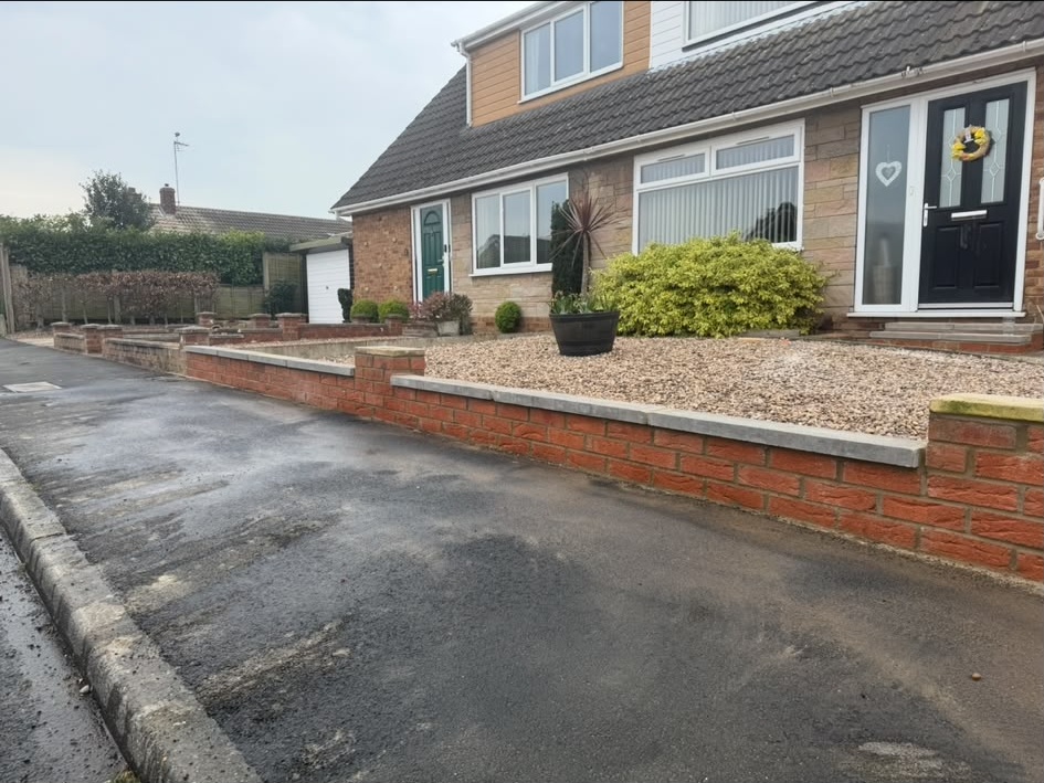 Finished front garden wall with new toppers outside a home