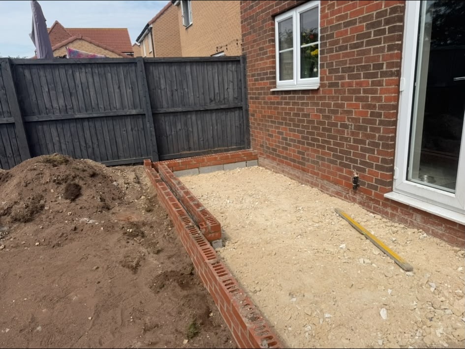 Brick edging and prepared base next to a house